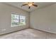 Bright bedroom features a ceiling fan, neutral paint, and a large window with views of the neighborhood at 101 Wins Walk, Cartersville, GA 30121