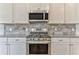 Close-up showcasing the kitchen's stainless steel range, microwave, and granite countertops with backsplash at 101 Wins Walk, Cartersville, GA 30121