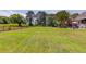 Sprawling backyard with an iron fence, mature trees, and patio furniture for outdoor relaxation and entertainment at 1292 Green Turf Dr, Snellville, GA 30078