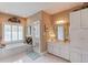 Well-lit bathroom features a soaking tub, shower, white cabinets and tile floor at 1292 Green Turf Dr, Snellville, GA 30078