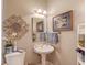 Charming powder room with pedestal sink, decorative mirror, and wall art at 1292 Green Turf Dr, Snellville, GA 30078