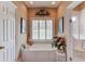 Bathroom with a garden tub, large window, framed art, and a tiled floor at 1292 Green Turf Dr, Snellville, GA 30078