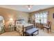 Bedroom with bed, bench, ceiling fan, and floral window treatments at 1292 Green Turf Dr, Snellville, GA 30078