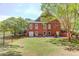 Exterior view of the brick home with a spacious backyard, iron fence, and a cozy patio area at 1292 Green Turf Dr, Snellville, GA 30078