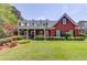 Charming brick home with a large front porch, lush landscaping, and a well-manicured lawn at 1292 Green Turf Dr, Snellville, GA 30078