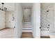 Hallway view of a white marble tiled bathroom with gold shower head and tub at 1962 8Th St, Chamblee, GA 30341