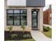 Contemporary home entrance with black door, transom windows, modern lighting, and professionally landscaped yard at 1962 8Th St, Chamblee, GA 30341