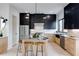 Contemporary kitchen featuring stainless appliances, a center island with seating, black upper cabinets, and light wood lowers at 1962 8Th St, Chamblee, GA 30341