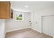 Bright laundry room with wooden cabinets, a window and clean white walls and light wood-look floors at 2139 Cedarbrook Court South East, Atlanta, GA 30316
