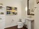 Powder room featuring wood floors, pedestal sink, and decorative wall art at 270 17Th Nw St # 1113, Atlanta, GA 30363