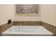 White soaking tub with tiled surround and modern fixtures at 270 17Th Nw St # 1113, Atlanta, GA 30363