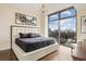 This bedroom features a large window with a city view, a chandelier, and hardwood floors at 270 17Th Nw St # 1113, Atlanta, GA 30363