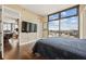Modern bedroom featuring wood floors, large windows with city views and a wall-mounted TV at 270 17Th Nw St # 1113, Atlanta, GA 30363