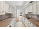 Galley kitchen with white cabinets, modern tile backsplash, and a view to the dining area at 49 Willow Gln, Atlanta, GA 30342