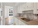 The kitchen features stainless steel sink, stylish backsplash, and white cabinetry at 49 Willow Gln, Atlanta, GA 30342