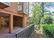 Back porch and backyard with beautiful green landscape, brick patio, and dark wood railing at 49 Willow Gln, Atlanta, GA 30342