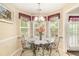 Bright breakfast nook featuring a round glass table, metal chairs, and bay windows at 1335 Vine Cir, Mcdonough, GA 30253