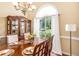 Sunlit dining room with a china cabinet and natural light filtering through the large window at 1335 Vine Cir, Mcdonough, GA 30253