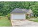 Exterior view of a charming home with an attached garage, green lawn, and manicured shrubbery at 1335 Vine Cir, Mcdonough, GA 30253