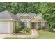 Inviting home exterior showcasing a well-kept lawn, mature shrubs, and stone accents at 1335 Vine Cir, Mcdonough, GA 30253