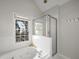Bright bathroom featuring a soaking tub, glass shower, and a large window at 174 Crumley St, Atlanta, GA 30312