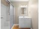Bright bathroom featuring a shower-tub combo, white vanity with storage, and decorative light fixture at 1903 Lochlomand Se Ln, Smyrna, GA 30080