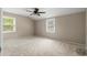 A carpeted room featuring two windows, a ceiling fan, and neutral wall color at 1903 Lochlomand Se Ln, Smyrna, GA 30080