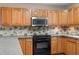 Updated kitchen featuring granite countertops, stainless microwave, and tile backsplash at 1903 Lochlomand Se Ln, Smyrna, GA 30080