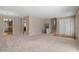 Open-concept living room featuring neutral carpet, staircase, and access to kitchen at 1903 Lochlomand Se Ln, Smyrna, GA 30080