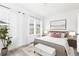 Serene bedroom showcasing a large window, king bed, tufted ottoman, and neutral color palette at 2676 Brookview Nw Ln, Atlanta, GA 30318