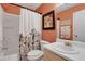 Well-lit bathroom featuring tub with shower, white vanity, and decorative accents at 3001 Garland Sw Dr, Marietta, GA 30008