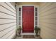 Welcoming entryway featuring a red front door, decorative wreath, sidelights, and potted plants, creating a warm entrance at 3001 Garland Sw Dr, Marietta, GA 30008