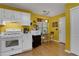 This kitchen includes white cabinetry, gas stove, hardwood floors, and a quaint breakfast nook at 3001 Garland Sw Dr, Marietta, GA 30008