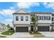 Exterior view of a townhome with a two-car garage and manicured landscaping at 711 Dodd N Ln # 166, Buford, GA 30518