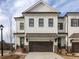 Charming townhouse features a white brick exterior, black windows, and a two-car garage, enhancing curb appeal at 711 Dodd N Ln # 166, Buford, GA 30518