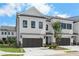 Exterior view of newly built townhomes featuring a two-car garage and manicured landscaping at 711 Dodd N Ln # 166, Buford, GA 30518