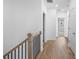 Hallway featuring hardwood floors and white walls with multiple closets and bedrooms at 711 Dodd N Ln # 166, Buford, GA 30518