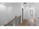 Upstairs hallway featuring hardwood floors and white walls with a view of the stairwell at 711 Dodd N Ln # 166, Buford, GA 30518