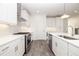 Bright kitchen features white cabinets, stainless steel appliances, gray wood floors, and an island with a sink at 711 Dodd N Ln # 166, Buford, GA 30518
