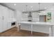 Bright kitchen with white cabinets, stainless steel appliances, island and hardwood floors at 711 Dodd N Ln # 166, Buford, GA 30518