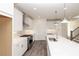 Bright, airy kitchen features an island, stainless steel appliances, modern lighting, and white cabinets with hardware at 711 Dodd N Ln # 166, Buford, GA 30518
