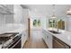 Modern kitchen with stainless steel appliances, quartz counters, and a view to the back yard at 711 Dodd N Ln # 166, Buford, GA 30518