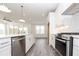Bright kitchen features stainless steel appliances, white cabinetry, and grey wood flooring at 711 Dodd N Ln # 166, Buford, GA 30518