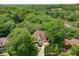 Stunning aerial view of a brown roof home nestled among lush trees near a serene lake, offering privacy and natural beauty at 95 Grogans Lndg, Atlanta, GA 30350