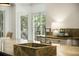 Close-up of a large kitchen island with a square prep sink, stone countertop, and views to the outdoor greenery at 95 Grogans Lndg, Atlanta, GA 30350