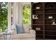 Bright living space with natural light, featuring a chair, side table, and large custom bookshelf at 95 Grogans Lndg, Atlanta, GA 30350