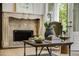 Cozy living room featuring a stone fireplace and views of the lush backyard at 95 Grogans Lndg, Atlanta, GA 30350