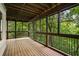Covered porch with wooden floors and swing, surrounded by lush greenery at 95 Grogans Lndg, Atlanta, GA 30350
