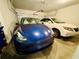 Garage interior with a blue sedan and a white sedan, under bright lighting at 1320 Stanley Park Dr # 141, Decatur, GA 30033