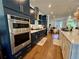 Modern kitchen with navy cabinets, stainless steel appliances, white countertops, and hardwood floors at 1320 Stanley Park Dr # 141, Decatur, GA 30033